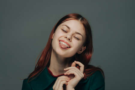 portrait of a red-haired woman on a gray background in a fashionable dress gesturing with hands Copy Spaceの写真素材