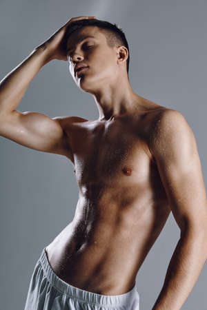guy bodybuilder with pumped up arm muscles on gray backgroundcropped viewの写真素材