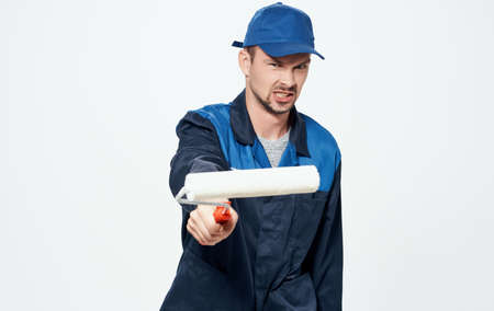 A man repairs yellow glasses and a roller to paint the walls