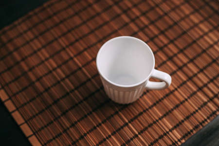 white mug on a wooden stand stands on the table top viewの写真素材