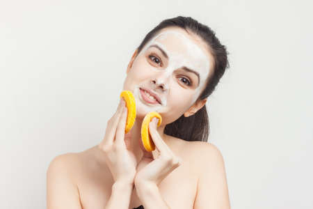 brunette with bare shoulders face mask sponges in handsの写真素材