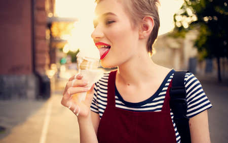 pretty woman with short hair eating ice cream outdoors leisure walk