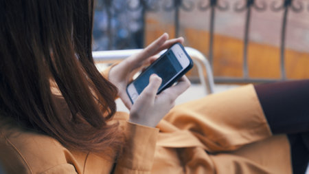 woman with a phone in her hands sitting in a cafe rest communicationの写真素材