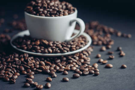 white cup with coffee beans on gray background Arabica varietyの写真素材