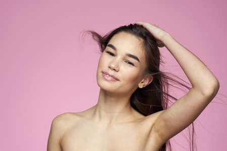 woman with bare shoulders clear skin body care pink backgroundの写真素材