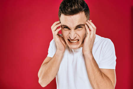 Emotional man white t-shirt displeased facial expression red isolated background cropped view