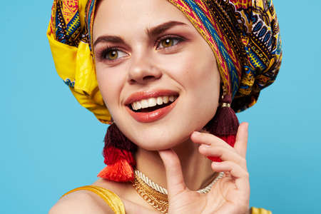 pretty woman multicolored turban decoration fashion close-up blue backgroundの写真素材