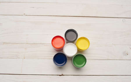 Multicolored paints and notepads on wooden table drawing background image mockup Posterの写真素材