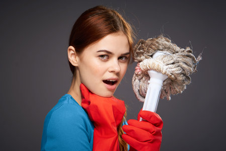 cheerful pretty woman cleaning lady mop in hand rubber gloves emotionsの写真素材