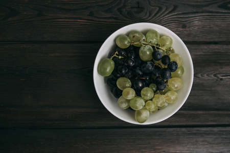 white and black grapes fruit vitamins freshness wooden backgroundの写真素材