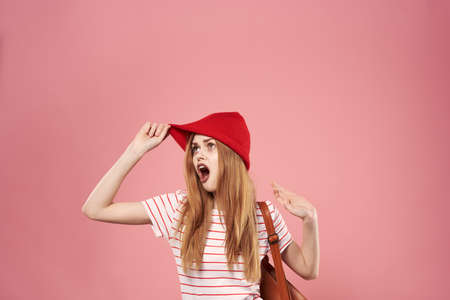 Cheerful fashionable woman in hat studio pink backgroundの写真素材