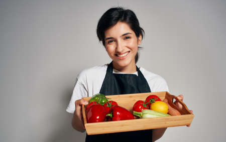 Woman chef in black apron slicing vegetables cooking food healthy food householdの写真素材