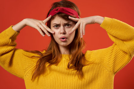cheerful woman yellow sweater glasses fashion clothes studio red backgroundの写真素材