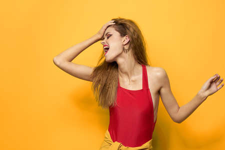 Cheerful pretty woman bright makeup red lips yellow backgroundの写真素材