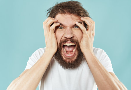 aggressive man yelling on blue background stress irritability emotions impulsiveの写真素材