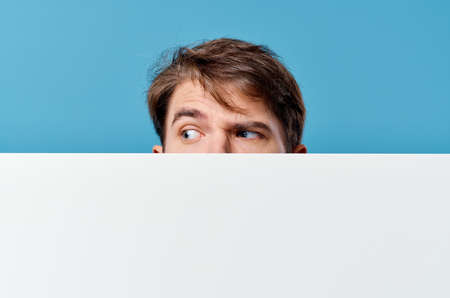 peeping from behind a billboard advertisement copy space isolated background close-upの写真素材