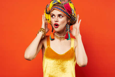 pretty woman multicolored turban decoration red lips attractive look red backgroundの写真素材