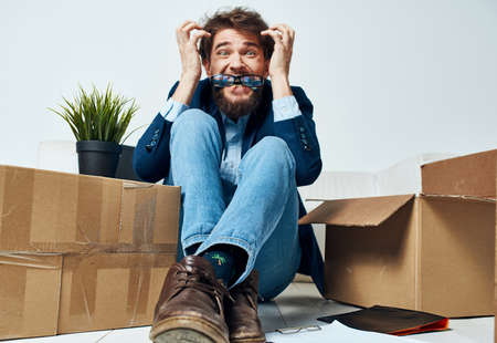 Emotional male manager unpacking lifestyle boxes in office