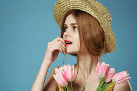 Elegant woman in a hat with a gift bouquet of flowers celebrate close-upの写真素材