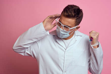 doctor in white coat medical mask treatment health professional pink backgroundの写真素材
