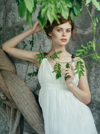 Pretty woman outdoors green leaves white dress summer walkの写真素材