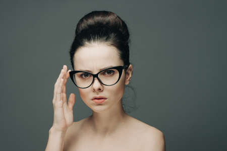 attractive woman with bare shoulders wearing glasses glamor fashion gray backgroundの写真素材