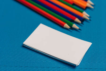 multicolored pencils and markers business cards close-up blue backgroundの写真素材