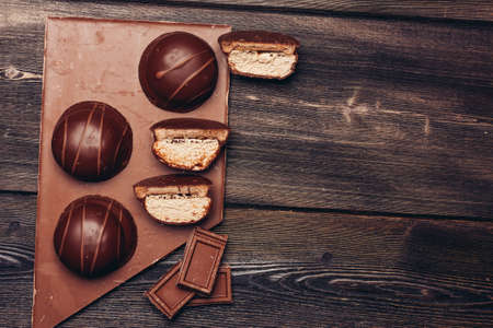 delicacy made of chocolate bars and pastries on wooden background texture dessertの写真素材