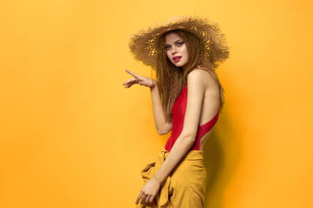 Woman in straw hat bright makeup summer lifestyle fun yellow backgroundの写真素材