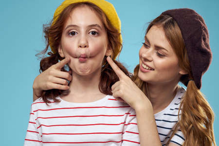 Mom and daughter striped T-shirts hugs fun lifestyle blue background
