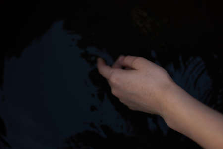 female hands on a dark background transparent water river nature fresh airの写真素材