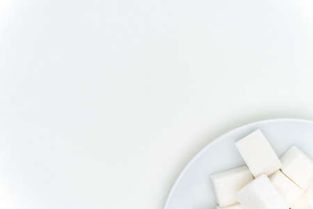 granulated sugar cubes on a plate sweets light backgroundの写真素材