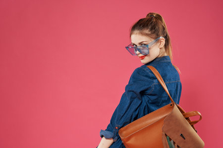 Emotional woman wearing glasses fashionable clothes backpack fun student lifestyleの写真素材