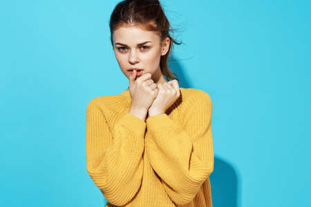 pretty woman in yellow sweater attractive look emotions close-up blue background