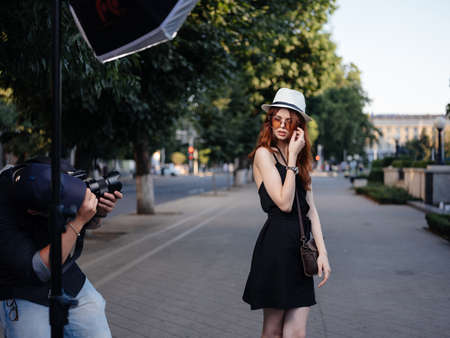 Woman posing on nature model hat bag black dressの写真素材
