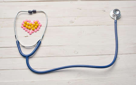 Scraping on the table and heart from pills wooden background texture health vitaminsの写真素材