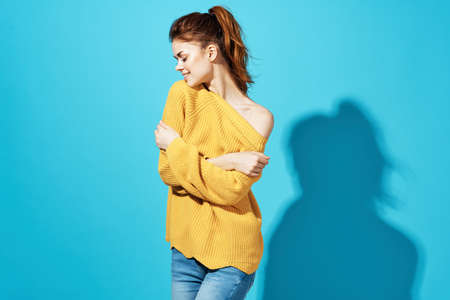 woman in yellow sweater fashion hairstyle casual wear Studio cropped view blue backgroundの写真素材