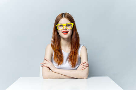 pretty woman in white dress sitting at the table yellow glasses emotions charm