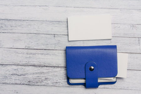 blue business card holder and white letterheads on a wooden table Copy Spaceの写真素材