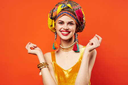 pretty woman multicolored turban decoration red lips attractive look red backgroundの写真素材