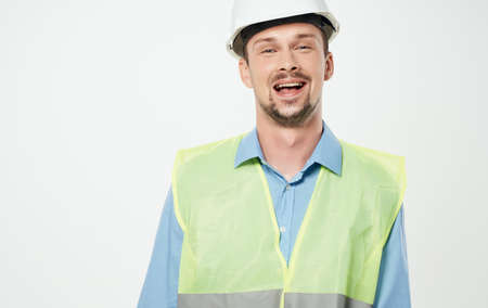construction worker in white helmet and green reflective vest