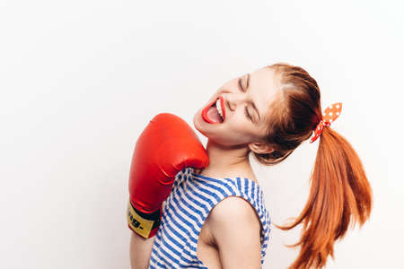 aggressive woman are engaged in boxing on a light background in a striped t-shirtの写真素材
