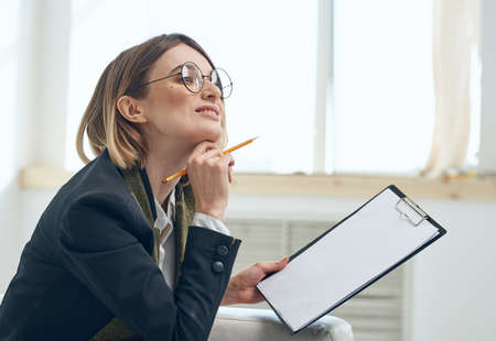 Business woman with documents classic suit bright room window