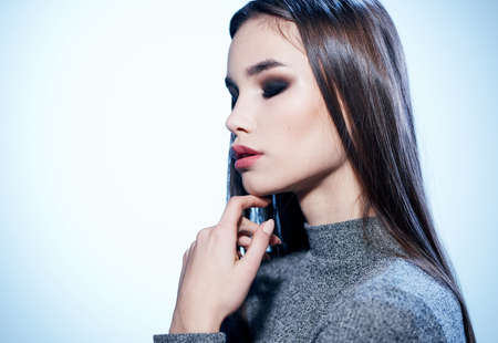 Portrait of beautiful brunette lady in gray sweater makeupの写真素材