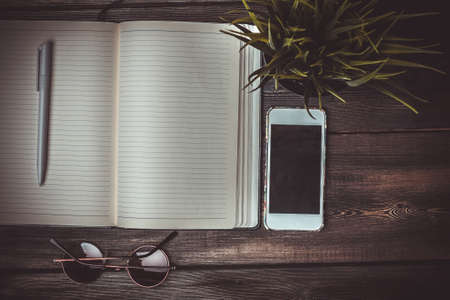 notebook with pen work desk sunglasses phone technology