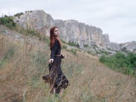 romantic Woman in black dress resting in nature in the mountains pretty womanの写真素材
