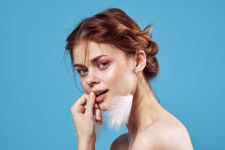 attractive woman naked shoulders earrings makeup freshness blue background