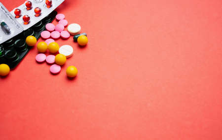 multicolored pills on red background medicine healthの写真素材