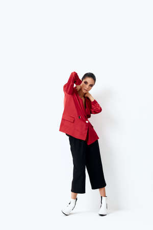 woman in red jacket holding hands behind head posingの写真素材