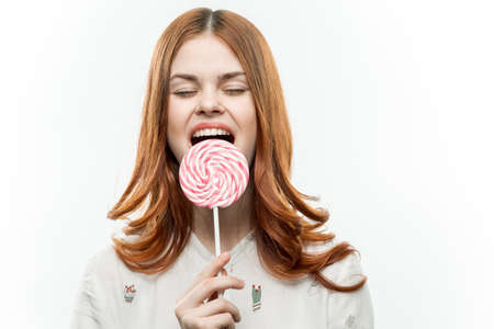 pretty woman licks round lollipop sweets joy emotionsの写真素材